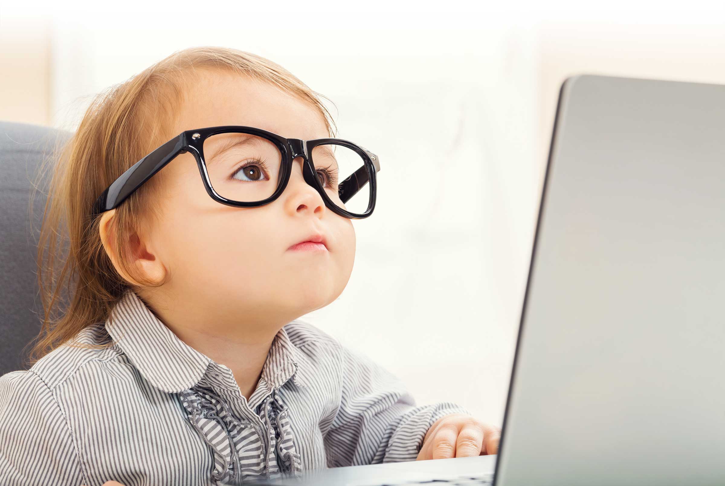 Young girl with glasses studying financial information on computer