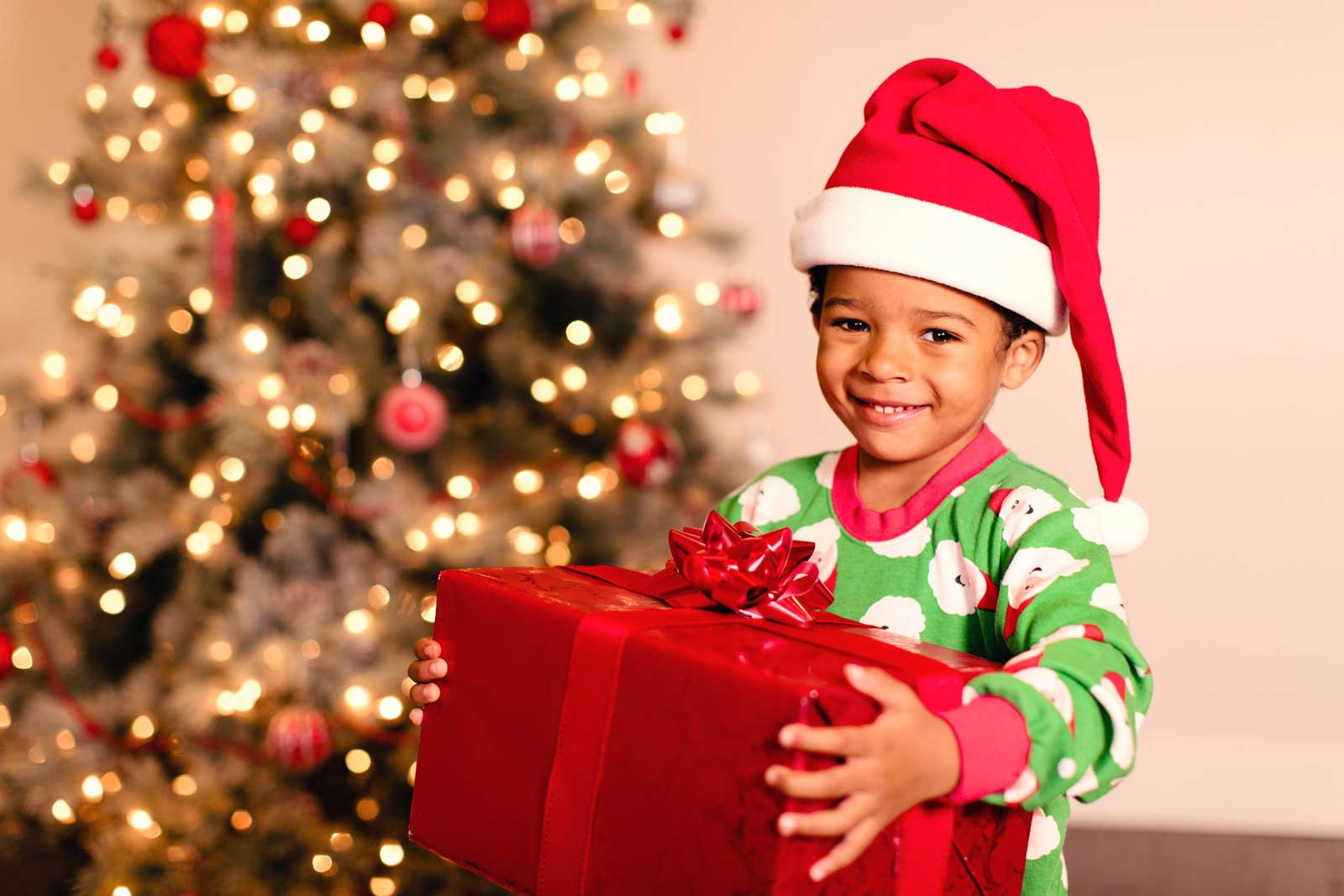 happy child with Santa hat holding gift